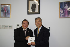 タイ大使（写真左）に目録を手渡す当社CSR室長
